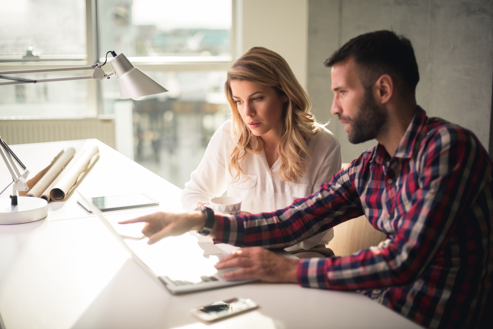 Coworkers sit down at a desk planning their next move for the business, post-pandemic.