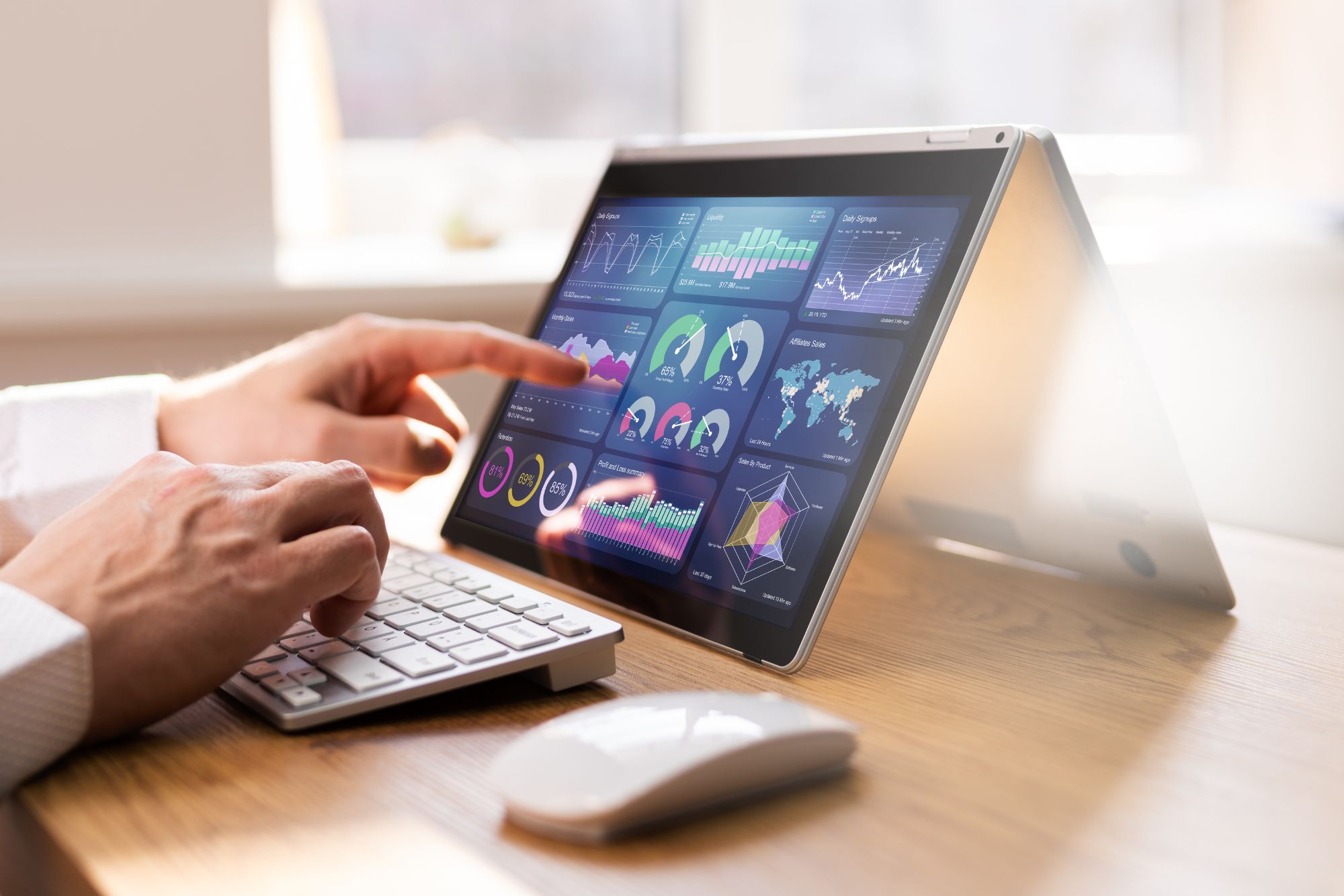 A man is at his desk working on a tablet-computer analyzing sales data to be successful in the coming fiscal year.
