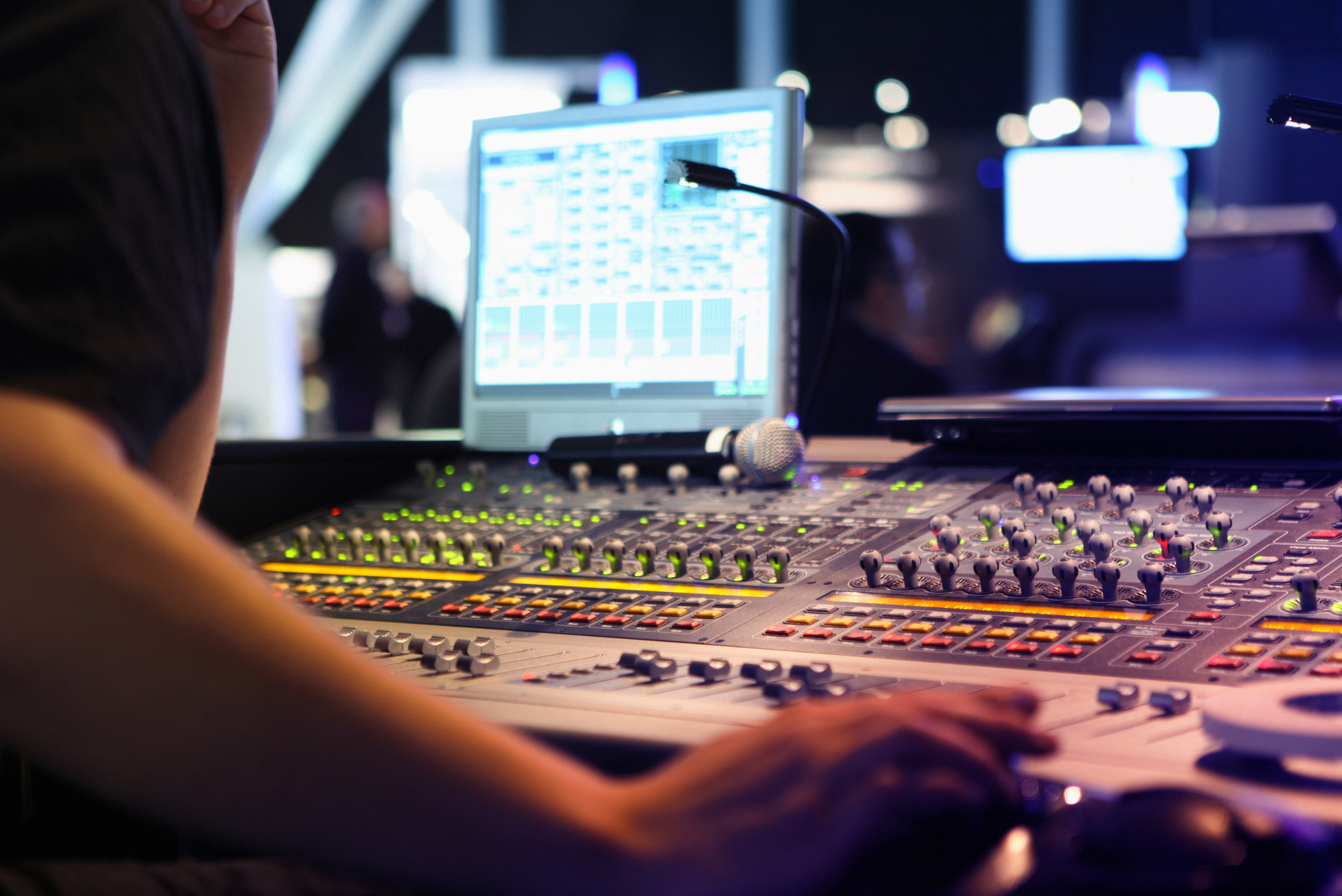 A good AV freelancer operates a large soundboard at a live event.