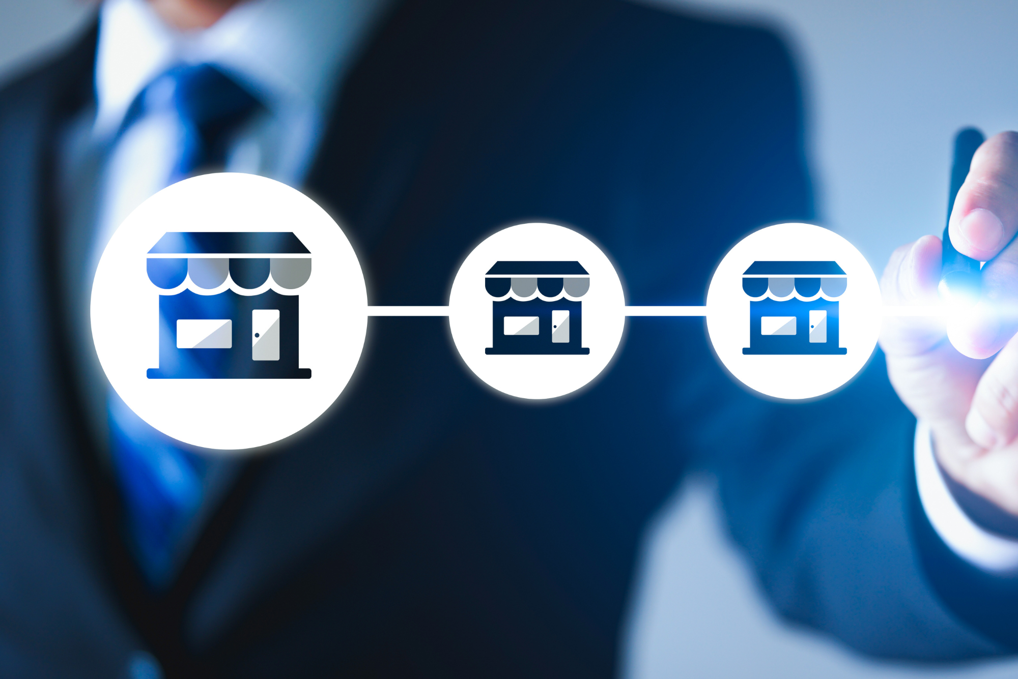 Three icons of store fronts connected by a horizontal line represent that a scalable business model is a franchisable model.