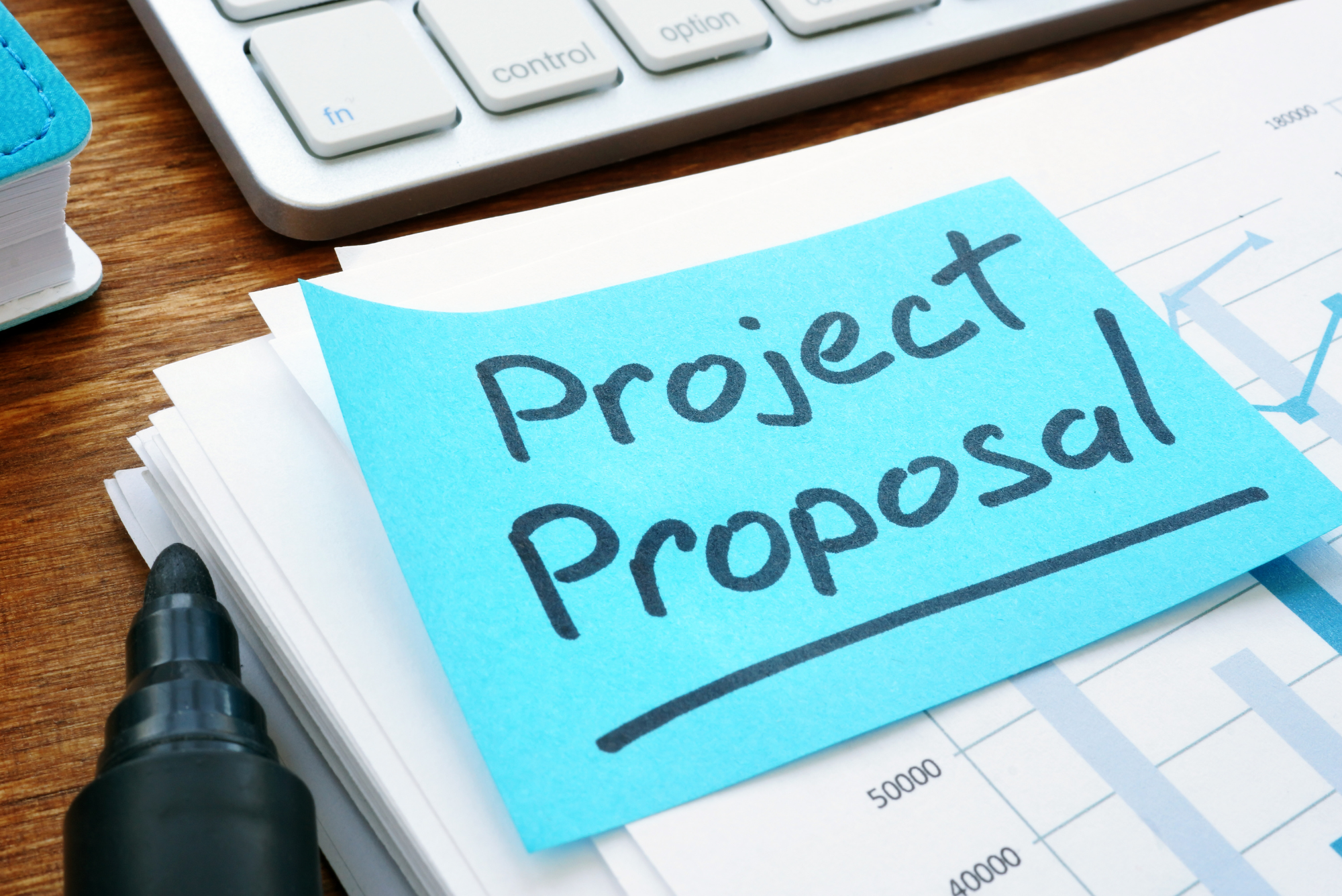 A blue sticky note with “Project Proposal” written on it sits atop a stack of documents detailing an event proposal.