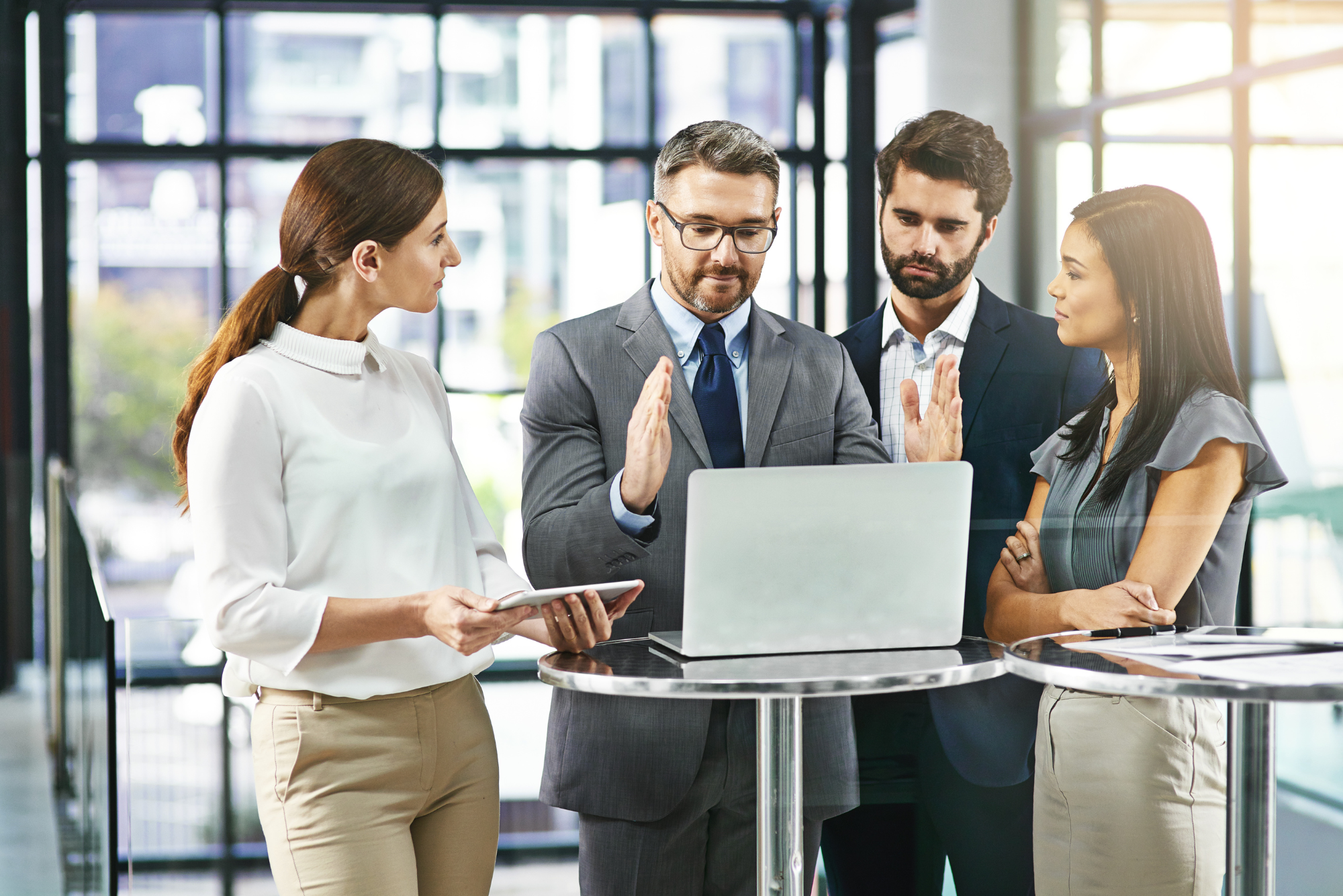 Business team having a discussion around a laptop.