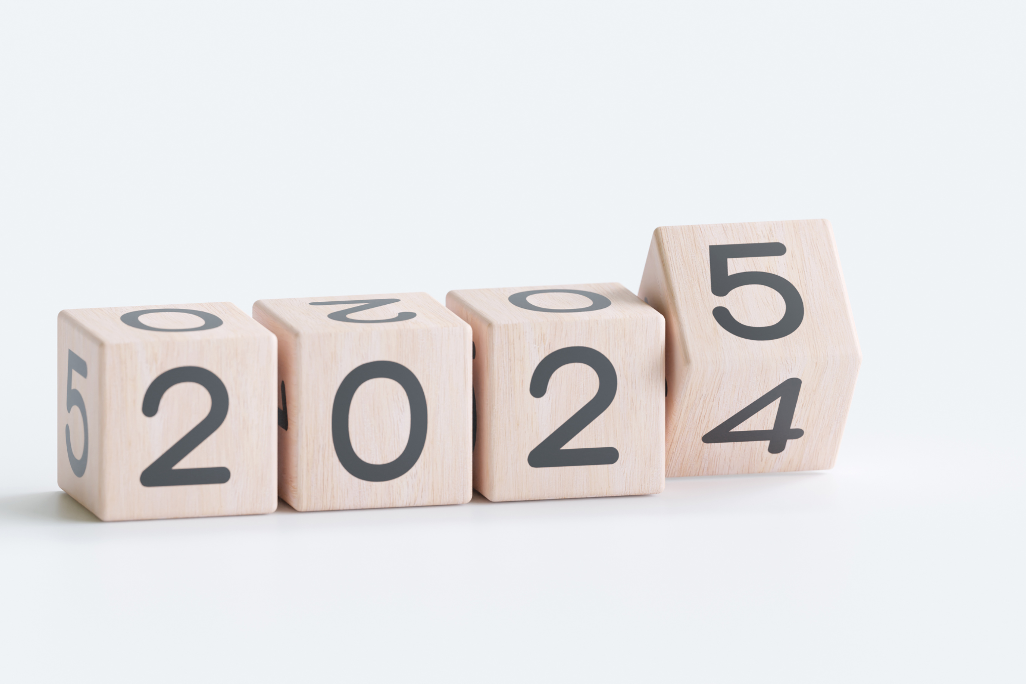 Wooden blocks transitioning from the year 2024 to 2025.