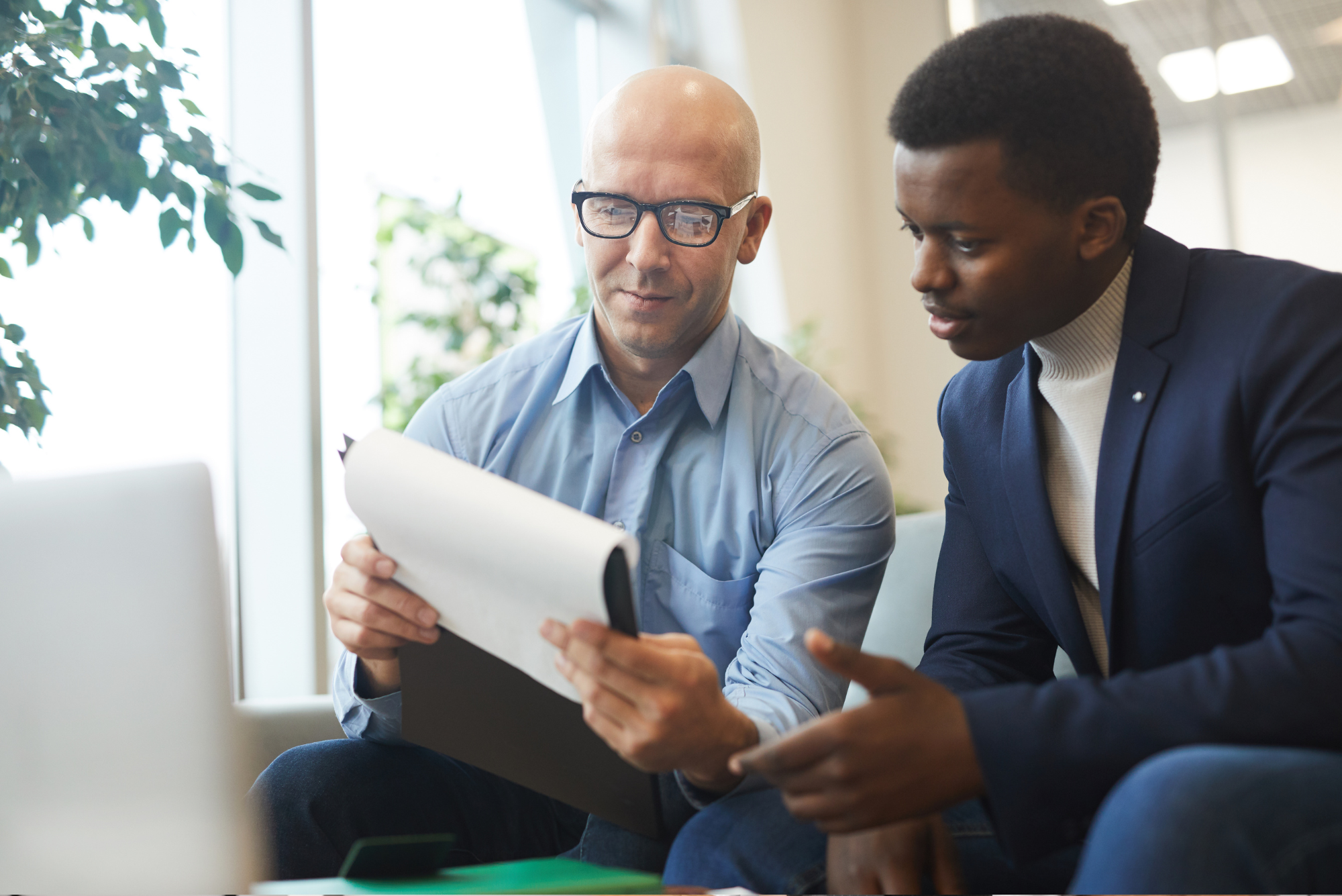 Two business professionals analyzing documents together.