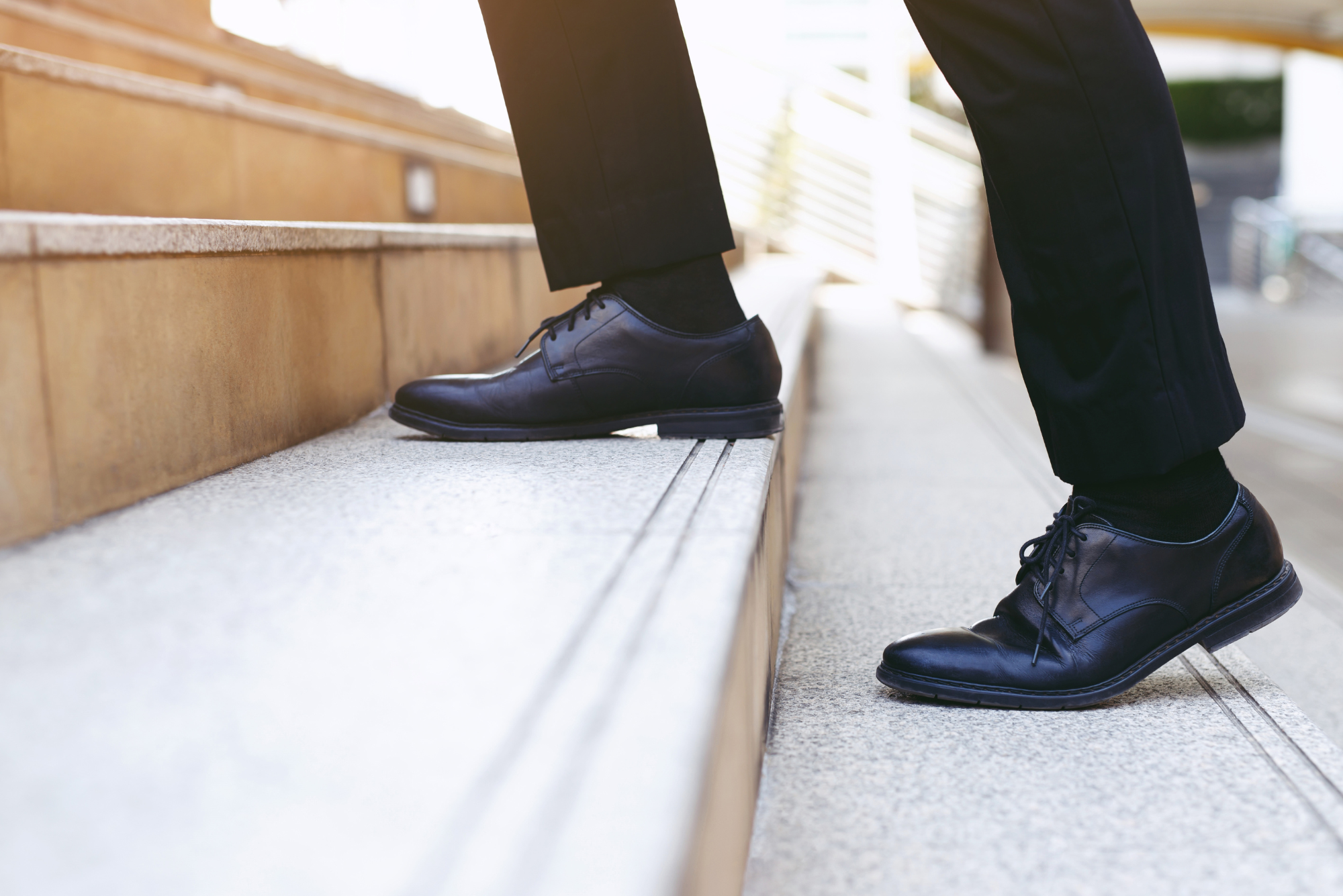 Image of person in dress shoes climbing stairs.
