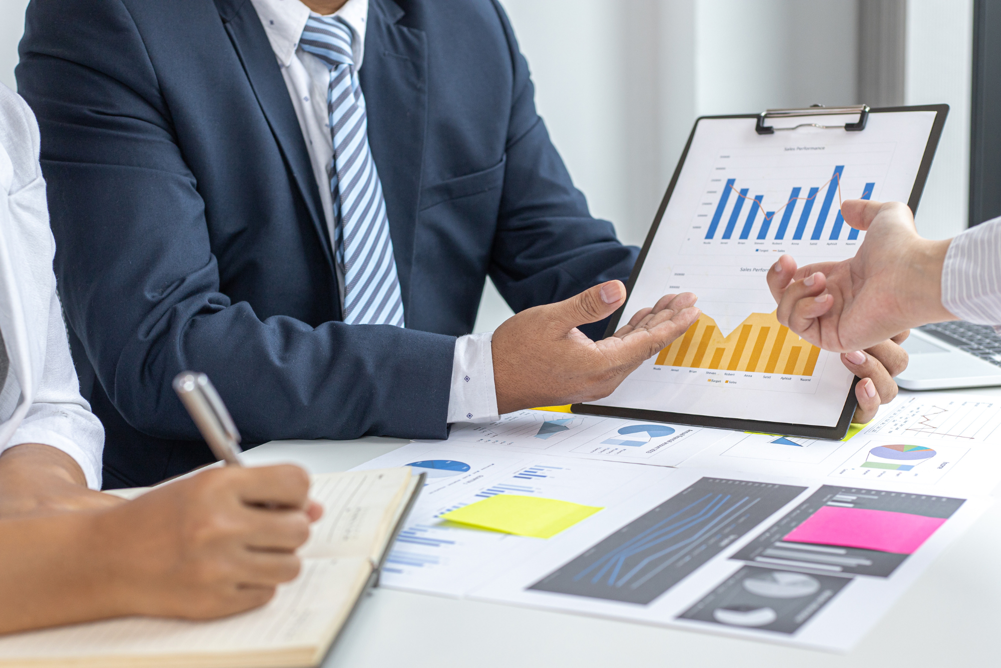 Business professionals review sales charts and financial data.