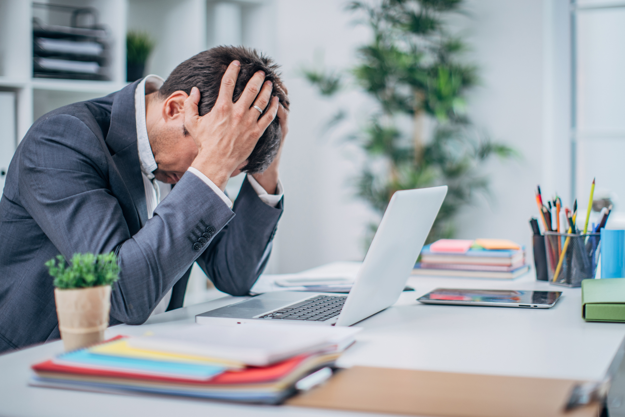 Business owner stressed at their desk, illustrating the need to stop retaining bad customers.