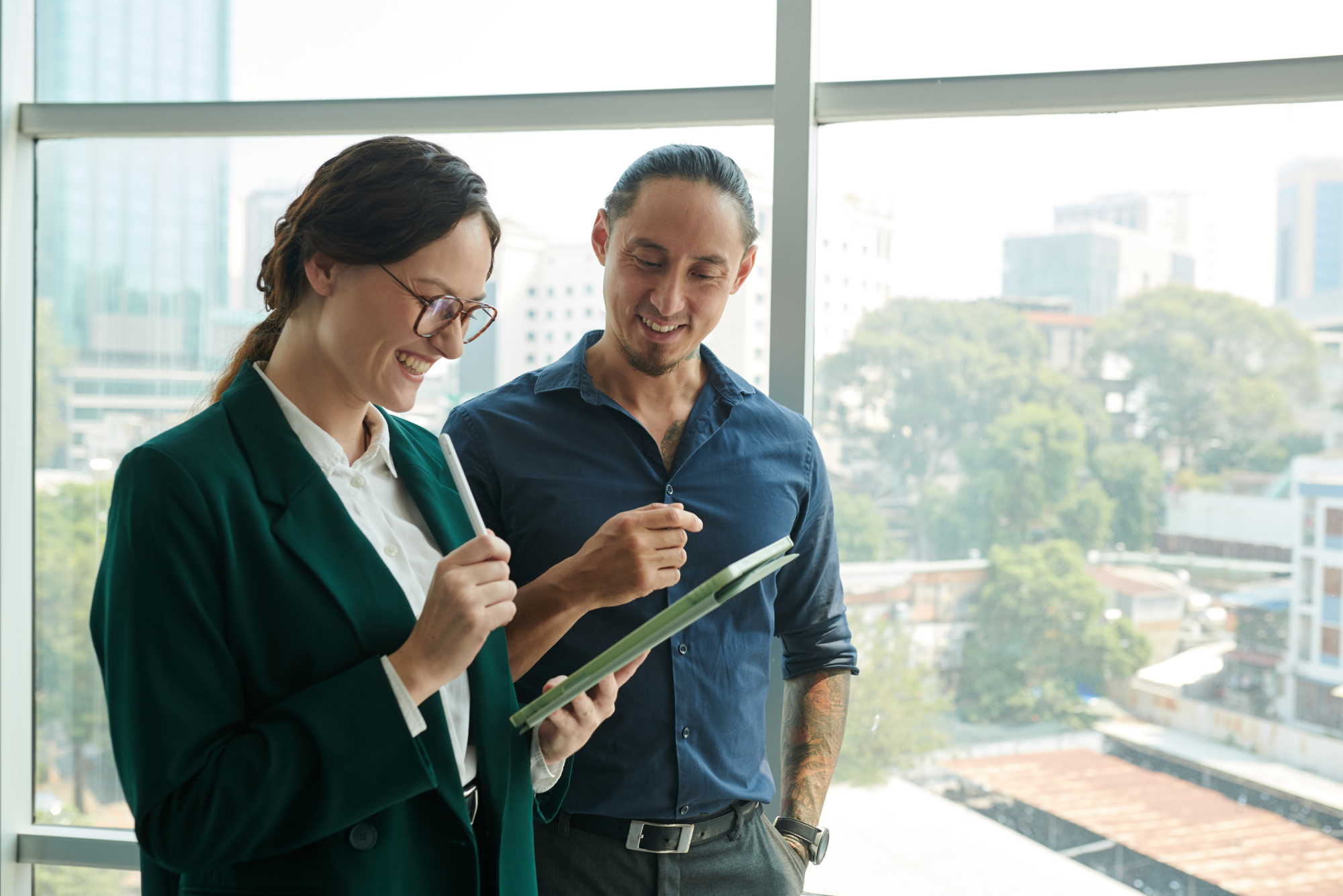 Two colleagues reviewing information together on a tablet.